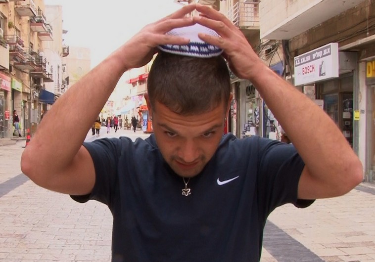 A man putting on a kippa as part of a solidarity campaign with European Jews