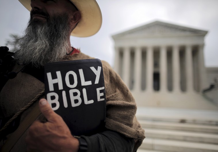 A protester holds a copy of the bible outside of the US Supreme Court building in Washington June 15, 2015. The US Supreme Court on Monday rejected a bid by the state of North Carolina to revive its law requiring women seeking an abortion to have an ultrasound of the fetus performed and described to