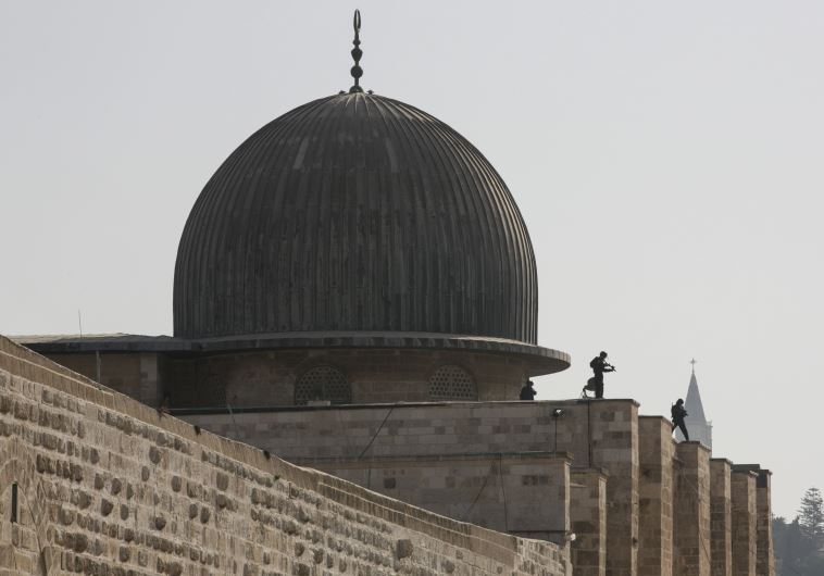 Israeli police officers take positions on the roof of the al-Aksa mosque during clashes with Palestinians in Jerusalem's Old City