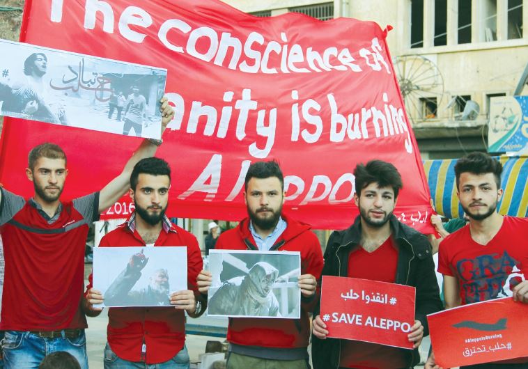 Men hold banners during a sit-in, showing solidarity with the people of Aleppo, in Idlib city, Syria, on May 4