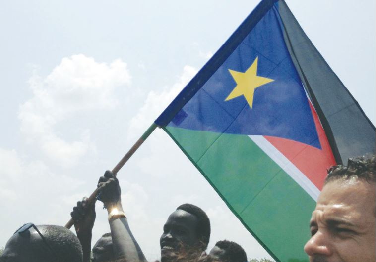 A PROUD CITIZEN waves the South Sudan flag at a pro-government demonstration on Monday, the same day the Israel Forum for International Humanitarian Aid (IsraAID) became trapped by the local internecine conflict.