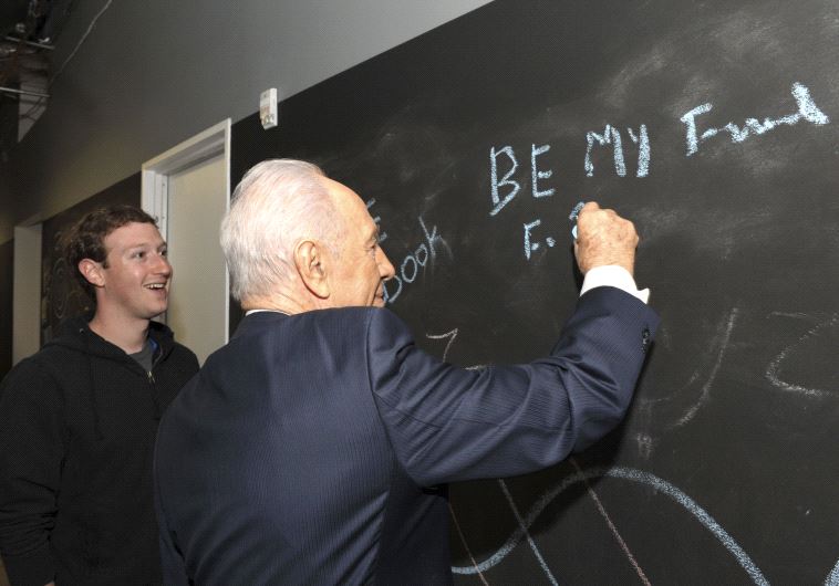 Shimon Peres writes on a blackboard with Facebook's CEO Mark Zuckerberg at the company's headquarters in Menlo Park, California, March 2012