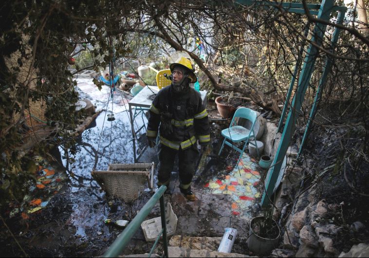 A firefighter surveys the damage from a fire in Haifa