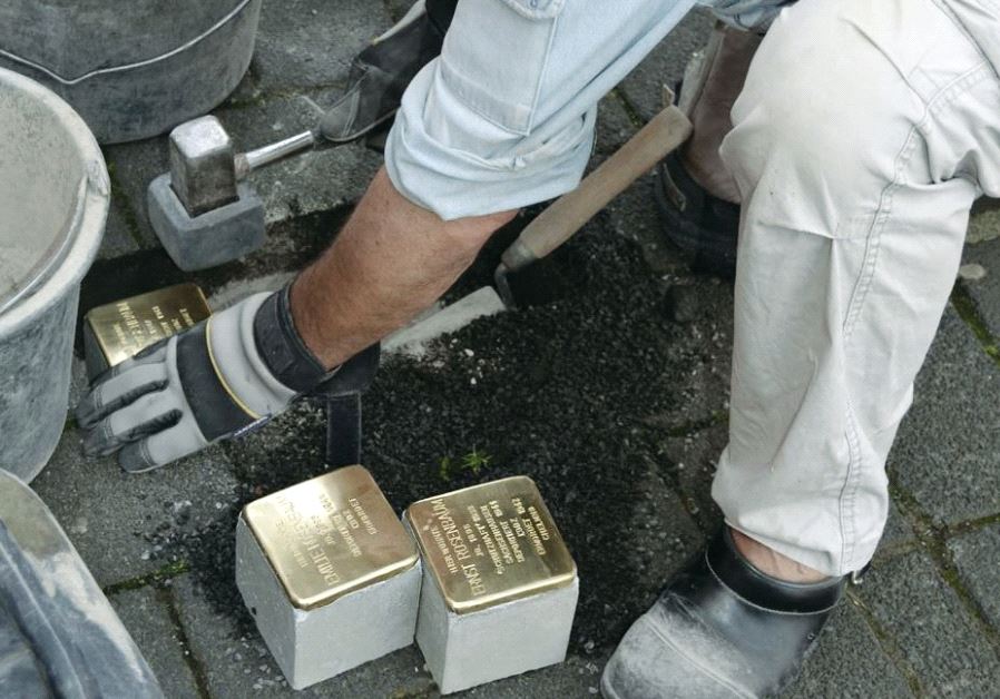 Artist Gunter Demnig lays Stolpersteine, small brass plaques that commemorate victims of the Nazis, in Cologne in 2015