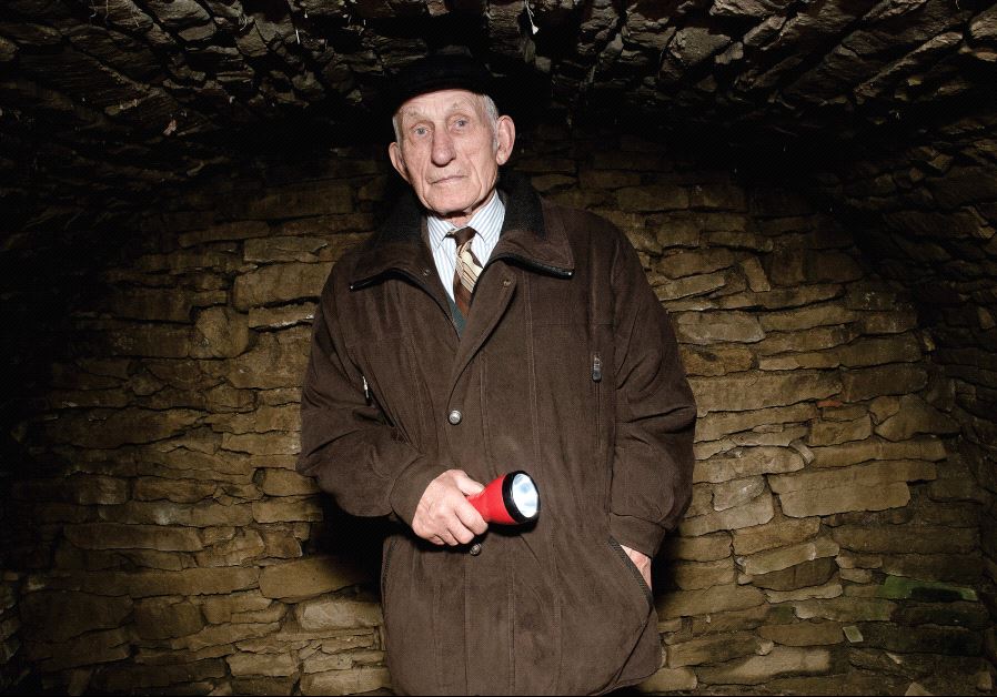 Jozef Jarosz inside the dugout where his family sheltered 14 Jews for almost two years during WWII