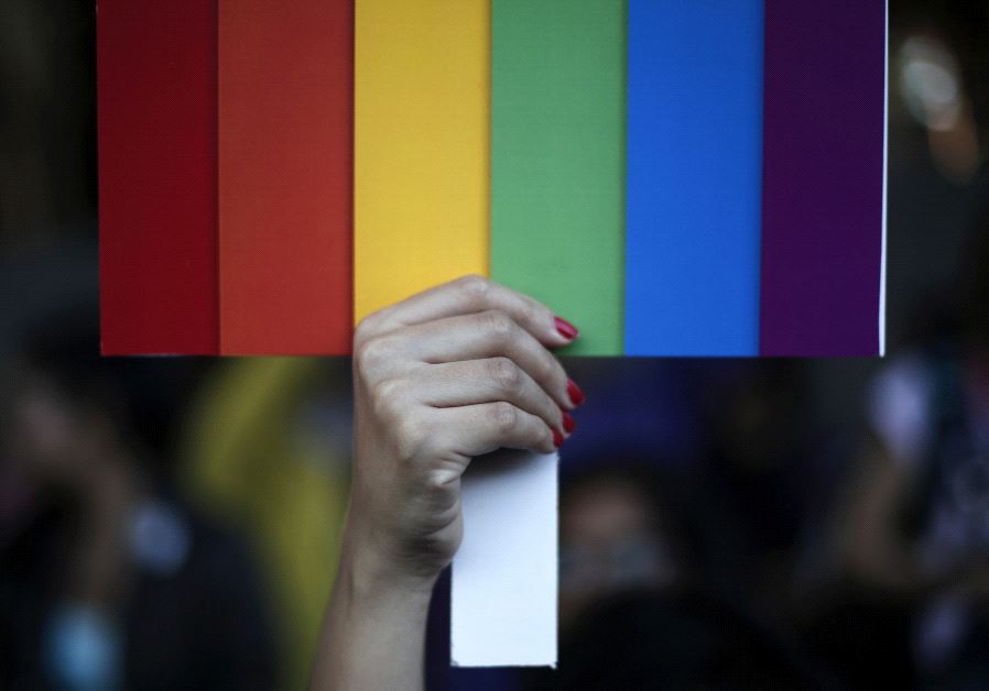 A rainbow coloured placard in the colors of the LGBT flag [Illustrative]