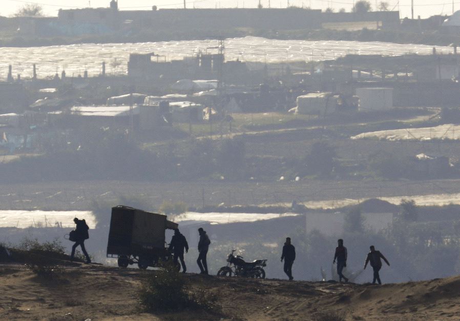 PALESTINIANS WALK near the Israel-Gaza border inside Gaza, where Hamas still holds Israeli citizens.