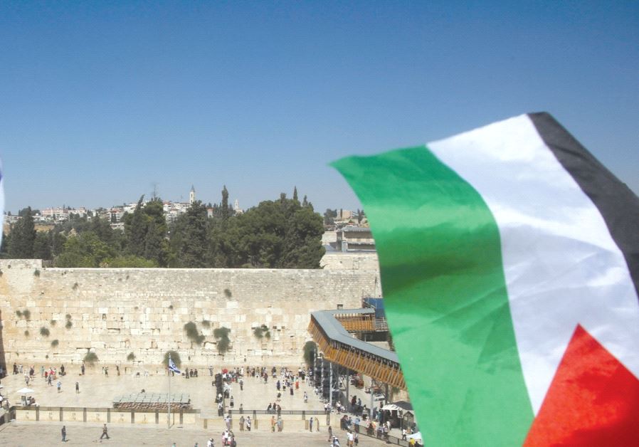 A Palestinian flag is seen waving in front of the Kotel