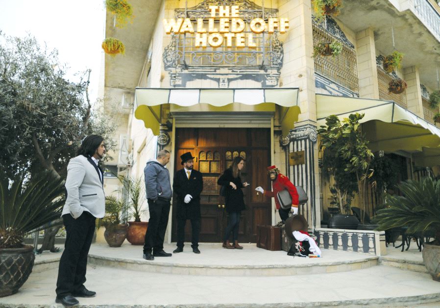A statue of a chimpanzee bellboy graces the entrance of the Walled Off Hotel in Bethlehem