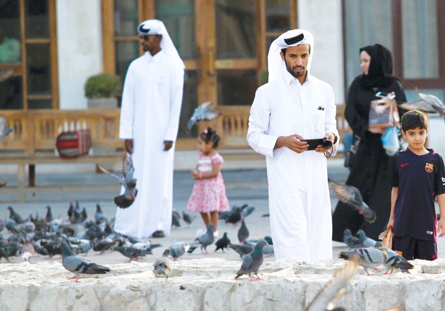 People look at pigeons at the Souq Waqif market in Doha, Qatar