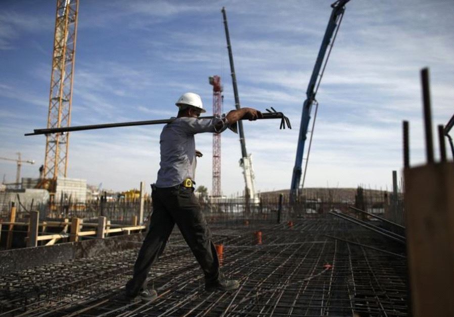 A laborer works on an apartment building under construction in the Har Homa neighborhood of Jerusalem